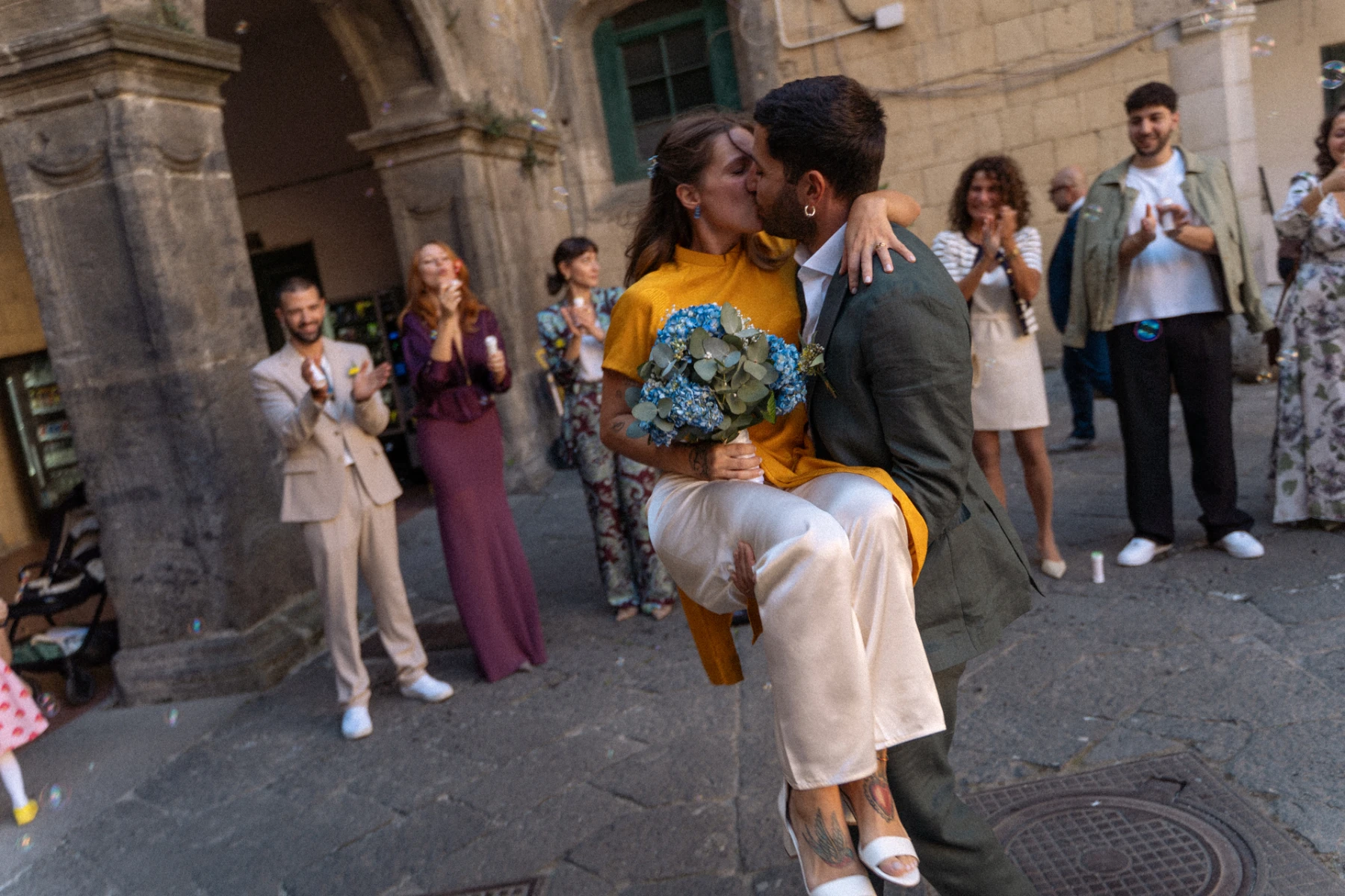 Lo sposo solleva la sposa e si baciano tra gli applausi degli invitati a Napoli