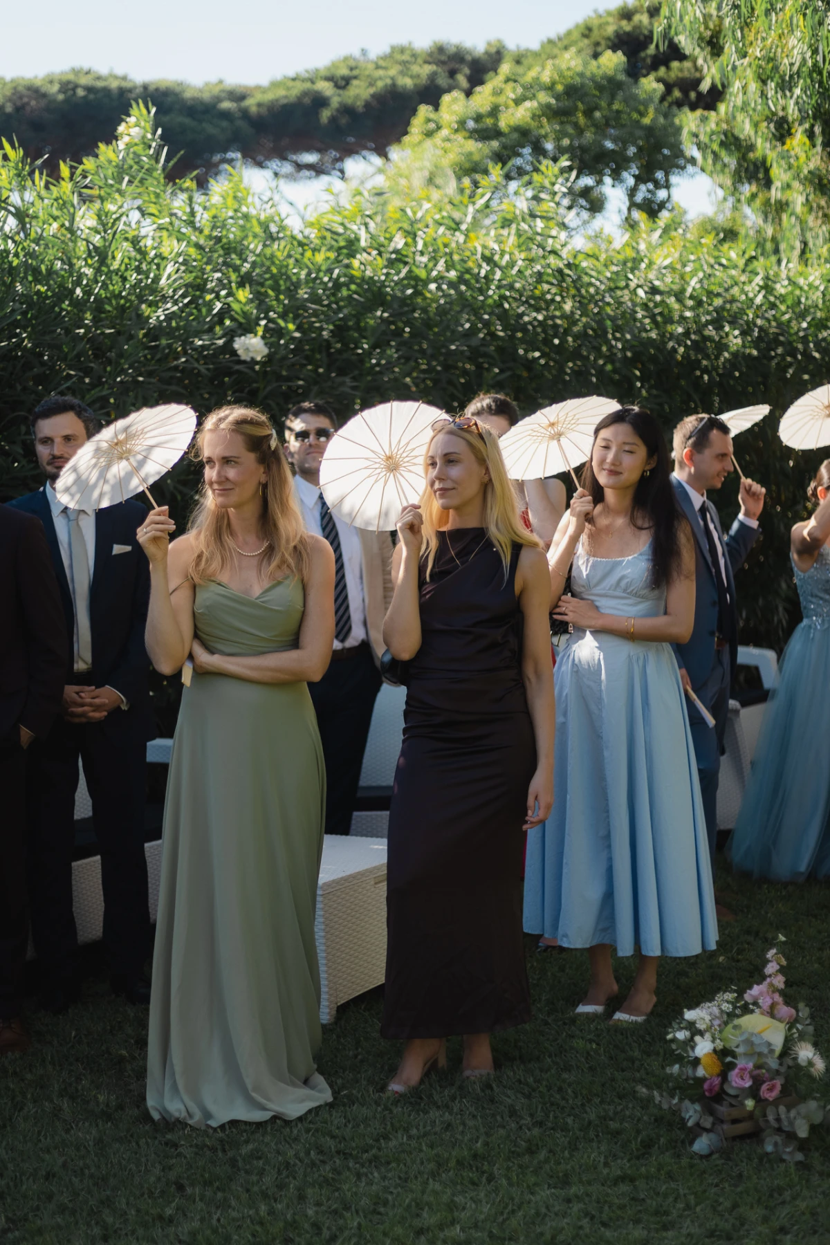 Le invitate con i parasole durante la cerimonia in giardino