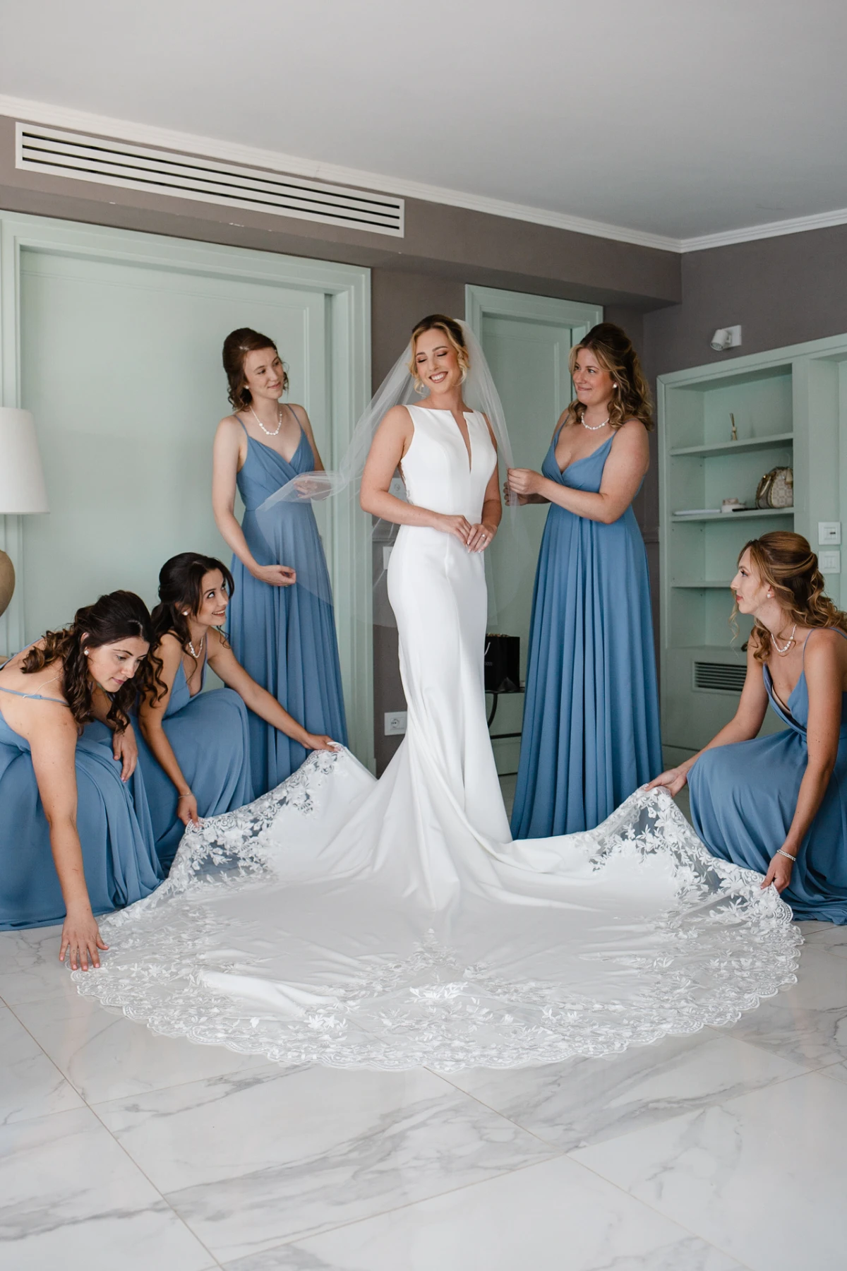 La sposa e le damigelle in blu sistemano lo strascico